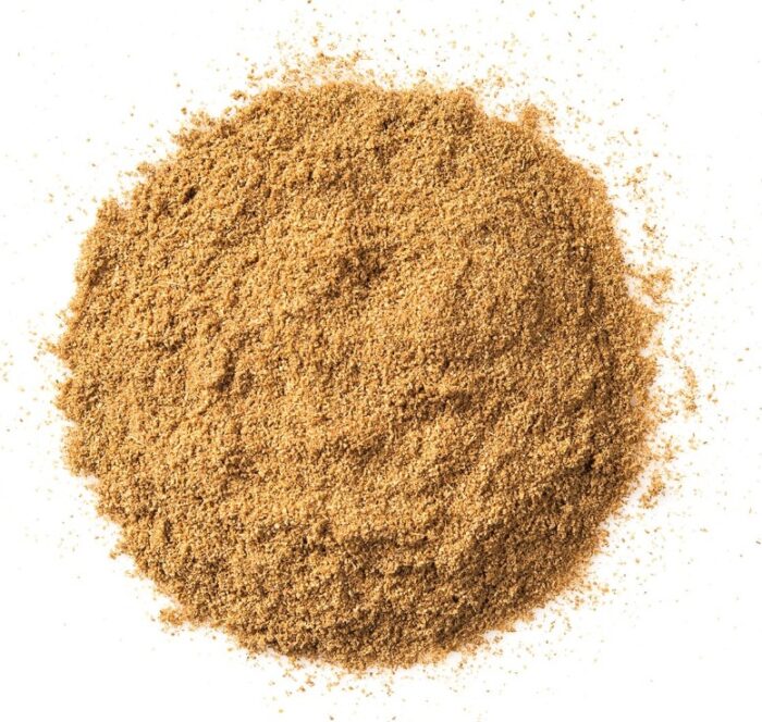 Circular pile of like brown cumin powder on a white background