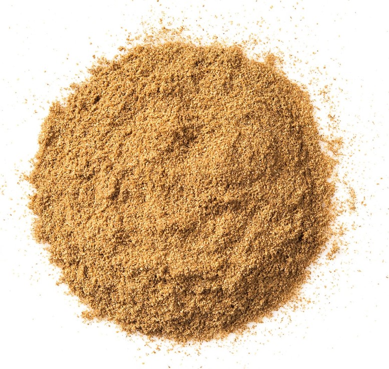 Circular pile of like brown cumin powder on a white background