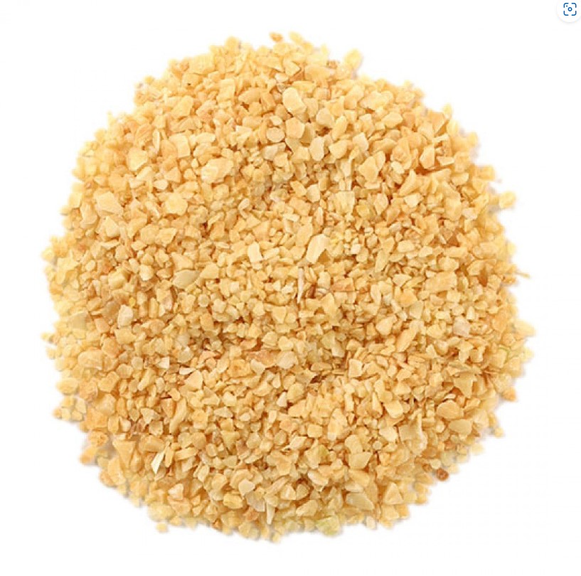 dried yellow brown garlic granules piled in a circle with a white background